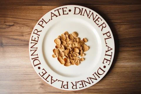 Large flat plate with crispy corn flakes closeup. Wooden background Stock Photos