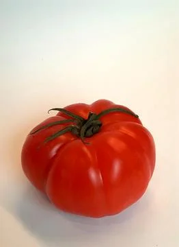 Large flat tomato, isolated on white background, shot from above at an angle Stock Photos
