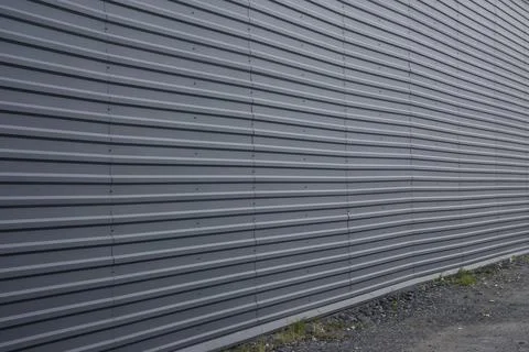 Large flat wall sheathed with gray metal roof sheets Stock Photos