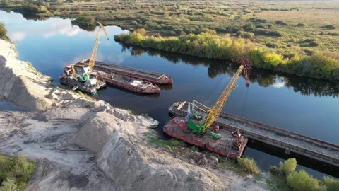 Large floating cranes unload bulk materials on the banks of the river. Stock Footage 219279866