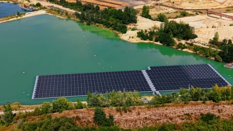 A large floating solar panel array deployed on a body of turquoise-green water. Vídeos de archivo 346190131