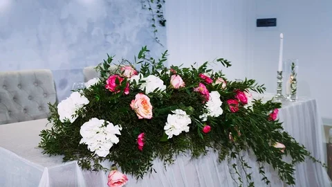 Large flower arrangement on a table decorated with a tablecloth Stock Footage 97721274