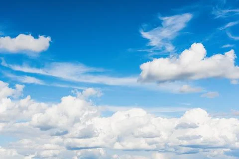 Large fluffy clouds on the blue sky in the daytime Stock-Fotos