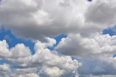 Large fluffy clouds float across the blue spring sky. Foto stock