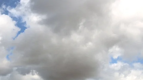 Large fluffy clouds quickly run across the blue sky Stock Footage 106353955