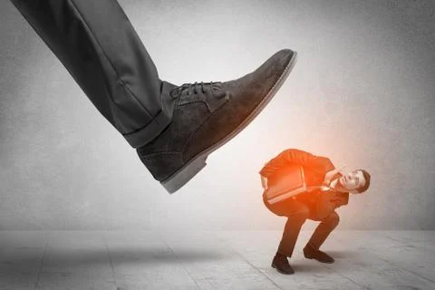 Large foot stepping down small man Foto stock