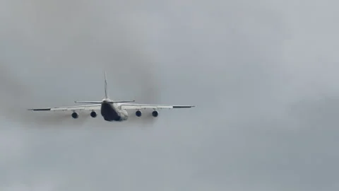 Large four engine cargo aircraft flying in overcast sky rear view Stock Footage 334369748