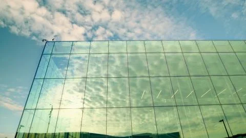 A large four-story building whose facade is made of glass on all sides Stock Photos