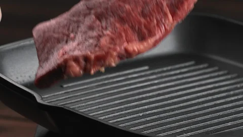 Large fresh raw chunk of delicious red beef or pork falls on a hot grill pan Stock Footage 123572080