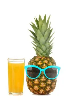 A large fresh ripe pineapple fruit in sunglasses with pineapple juice on a wh Stock Photos