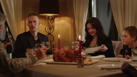 A large friendly family is having dinner at a restaurant. People sitting in a Video stock 237760031