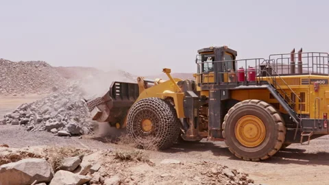 Large front loader in a dry, sandy area, transporting rocks and rubble Stock Footage 241215484