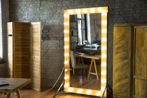 Large full-length mirror in a room with a brick wall and a window Stock Photos