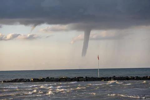A large funnel cloud is seen over the ocean 스톡 사진