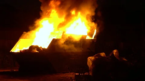 A large garbage container burns at night. Big flame with smoke Stock Footage 134421894