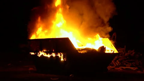 A large garbage container burns at night. Big flame with smoke Stock Footage 134422024