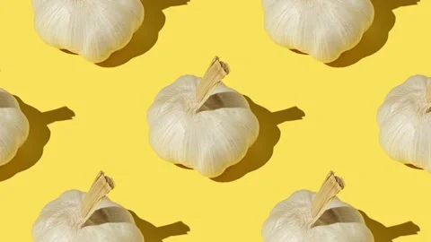 Large garlic cloves close up on a yellow background Stock Footage 169280534