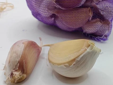 Large garlic on a white background, macro photography Stock Photos