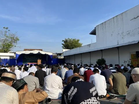 A large gathering of people doing eid prayer at the field. Foto stock