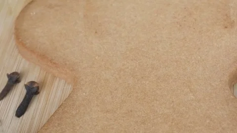 Large gingerbread cookie closeup with cloves and other ingredient on wooden Stock Footage 341499824