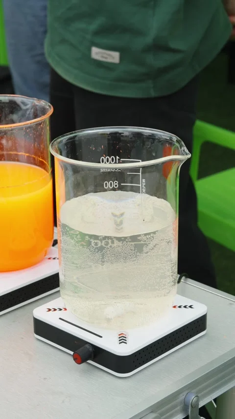 A large glass laboratory beaker filled with clear bubbling liquid rests on Stock Footage 339911891