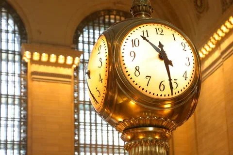 Large golden clock inside the train station providing help for travelers in.. Stock Photos