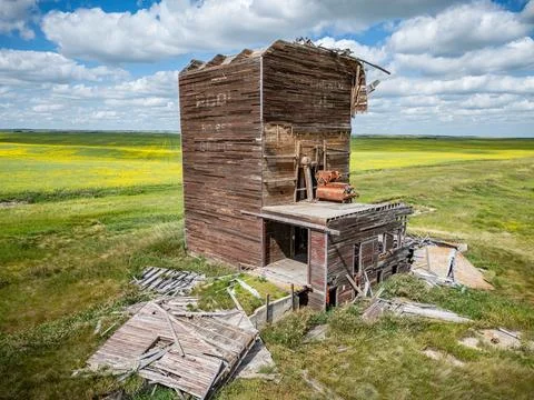 Large grain elevator with a lot of damage sits in a field Stock Photos