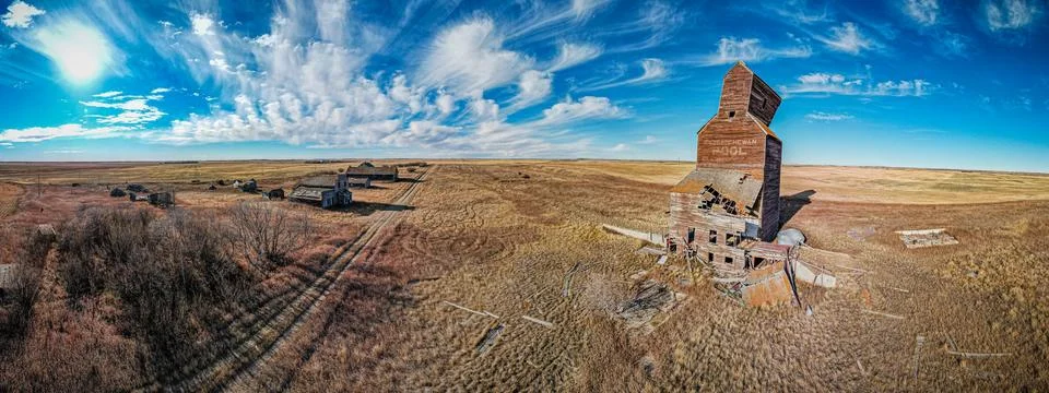A large grain elevator sits in the middle of a vast, empty field 스톡 사진