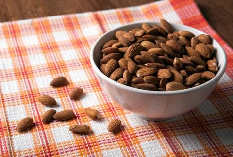 Large grains of almonds in the shell and the bowl Stock Photos