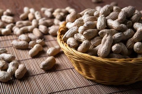 Large grains of peanuts in the shell and basket Stock Photos