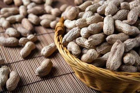 Large grains of peanuts in the shell and basket Stock Photos