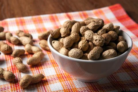 Large grains of peanuts in the shell and the bowl Foto stock