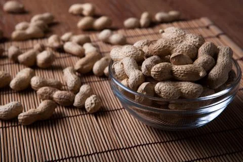 Large grains of peanuts in the shell and the bowl Stock Photos