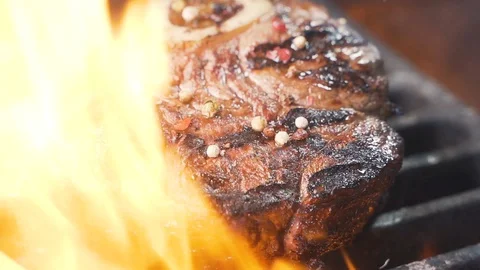 Large grains of pepper fall on juicy grilled filet mignon close up 스톡 동영상 107533901