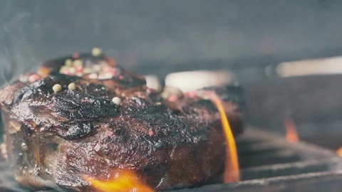 Large grains of pepper fall on juicy grilled filet mignon 스톡 동영상 107741370
