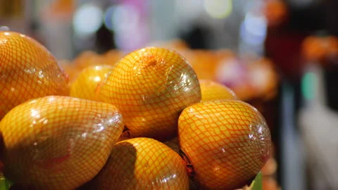 Large grapefruits are displayed in the fruit section of a busy supermarket. Stock-Footage 322549496
