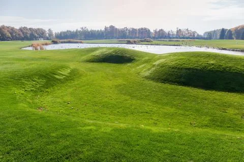 Large grassplot with mown grass and pond in the center Stock Photos