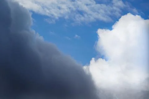 A large gray cloud and a large white cloud in the blue sky. Stock Photos
