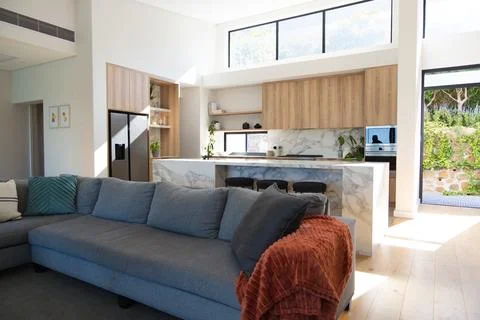 Large gray L-shaped sectional sofa is anchoring open living area near marble Stock Photos