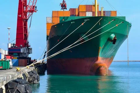 Large Green Cargo Ship Docked at Port with Stacked Containers Stock Photos