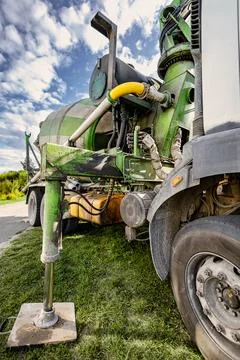 A large green machine sits on the ground, showing off its hydraulic system an Stock Photos