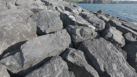 Large grey rock riprap breakwater along atlantic ocean shore Stock Footage 340459565