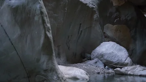 Large grey rocky cliffs of strange form surround lake water Stock Footage 143340726