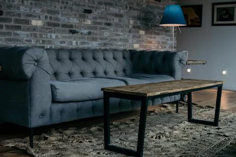 Large Grey Sofa By Brick Wall Stock Photos