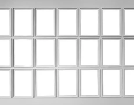 Large grid of empty white picture frames arranged in rows on a white wall. Stock Photos