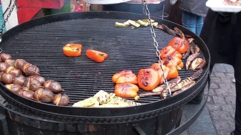 On a large grill the chef prepares zucchini and pepper. Sausage cut into pieces. Stock Footage 77383090