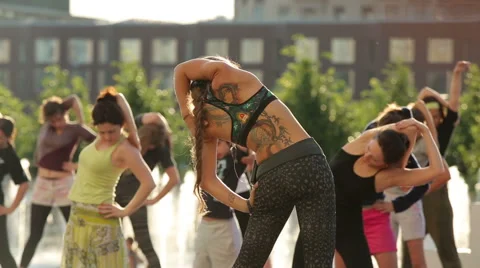 A large group of active young people practicing yoga in a city park Stock Footage 51932136