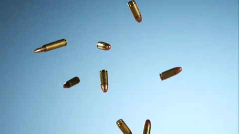 Large Group of Bullets and Rifle Cartridges Falling Against Blue Background Stock Footage 326292478