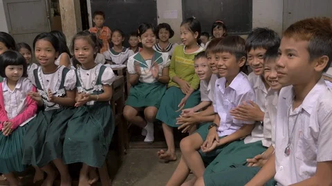 Large group of Burmese immigrant children clapping together at a Thai school Stock Footage 91337290