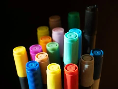 Large group of colored felt-tip pens with caps on a dark background Stock Photos
